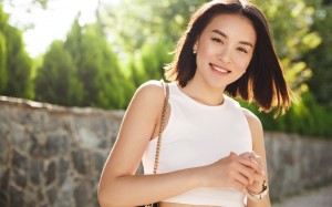 Image of modern asian woman standing in park and smiling. Stylish asia girl looking at camera with happy face, walking in city